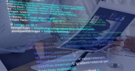 Colleagues analyzing data on tablet at office table, with laptop notebook pen chart glass water