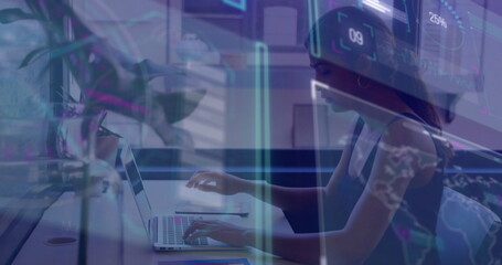 Analyzing holographic charts on laptop at home office desk, woman wearing tank top, notebook, plant