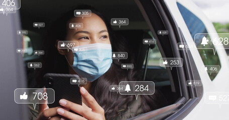 Holding smartphone masked passenger checking notification icons inside car near open window frame