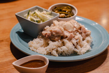 Steamed chicken rice dinner with side dishes
