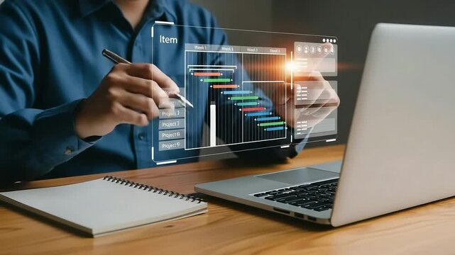 A person is planning a project using a digital gantt chart on a transparent screen while taking notes in a notebook