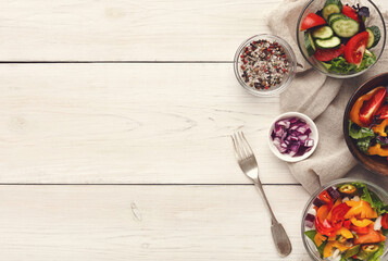 Assorted vegetable salad bowls on white wood top view. Fresh organic snack for vegetarian party food table, copy space. Healthy eating concept