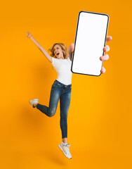 Emotional blonde woman jumping and shouting, going crazy, showing smartphone with space for new mobile app on screen, orange studio background. Collage with mockup for website