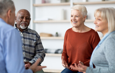 Excited multiethnic elderly people attending group therapy session at nursing house, positive senior man and woman sitting in circle, having conversation with psychologist and gesturing, closeup