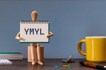There is notebook with the word YMYL. It is an abbreviation for Your Money or Your Life as...