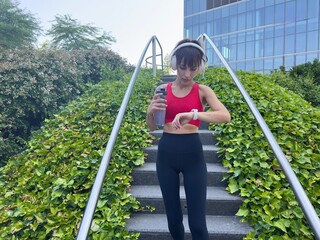 Fit woman checking smartwatch during workout