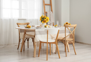 Elegant table serving with plates, glasses and beautiful sunflowers