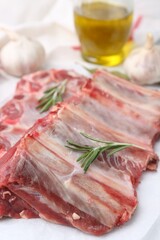 Fresh raw beef ribs and spices on table, closeup