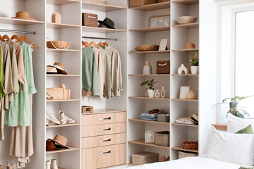 Wardrobe with stylish clothes, accessories and organizers in bedroom