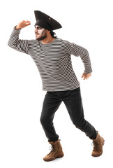 Young man dressed as pirate for Halloween looking at something on white background