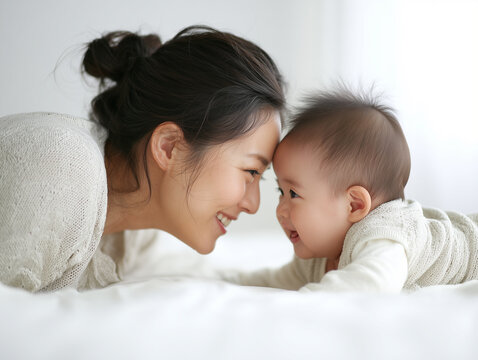 幸せそうに見つめ合う母親と乳児の親子写真