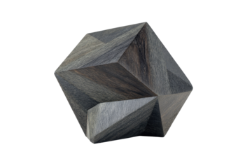 A dark, multifaceted wooden object, seemingly a geometric sculpture or puzzle piece. 