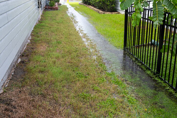After torrential rain water is running down swale in the yard between two houses