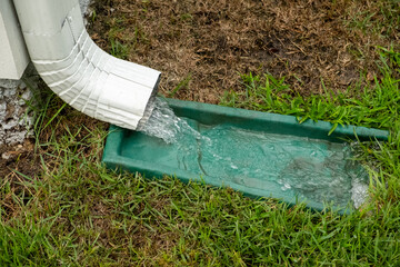 Close up of water gushing from downspout on a house during a severe rainstorm