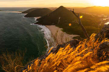 A golden sunset view of Zenith Beach from the summit lookout of Tomaree Head in Port Stephens, New...