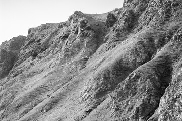 A rocky hillside with a person standing on top of it