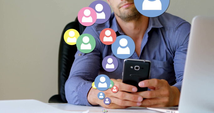 Checking smartphone office worker wearing blue shirt at desk with laptop and user profile icons - Powered by Adobe