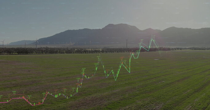 Showing translucent financial chart overlay over farmland, with wind turbines and power poles - Powered by Adobe