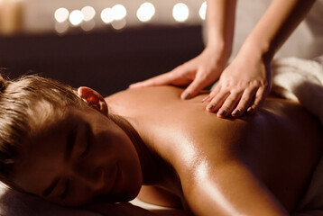 Masseur doing massage on woman back in spa salon, closeup