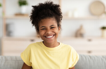 Positive Black Girl Laughing Sitting On Couch At Home. LOL, Good Joke, Sense Of Humor Concept