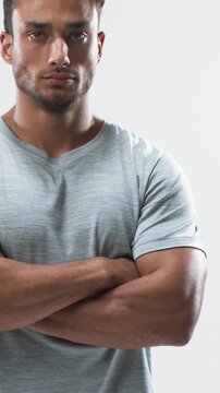 Vertical video: On camera start Hispanic man entering with arms crossed shifting gaze for portrait