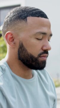 Vertical video: Man sitting in garden patio spotting motion fluttering eyelids turning and grinning
