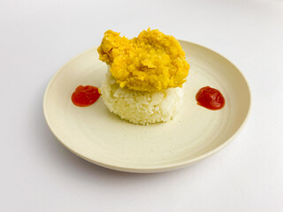 Crispy chicken fillet with cooked rice and sauce served on round plate, isolated on white background.