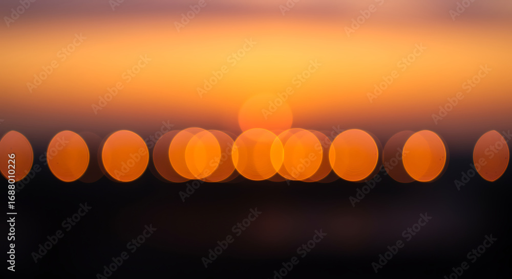 Poster abstract blurred lights creating a bokeh effect with warm orange tones against a dark background