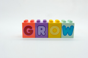 GROW alphabet on colorful building blocks isolated on a white background. Concept of toy, education, motivation, planning and hope