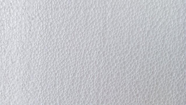 White expanded polystyrene foam sheet texture with a porous, bumpy surface, a versatile abstract background.