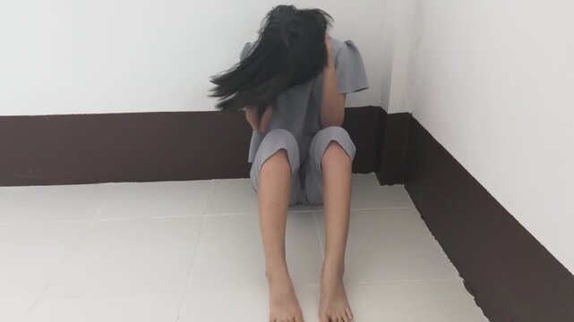 Sad young girl shaking her head sitting in the room, Domestic violence, family problems, Stress, violence, The concept of depression and suicide.