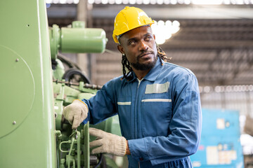 industrial worker in factory. African american factory male worker. Engineer man worker wearing yellow hard hat safety first at a heavy industrial factory.