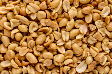 A full frame, closeup shot of oven-baked peanuts, highlighting their deep golden-brown color and roasted texture.