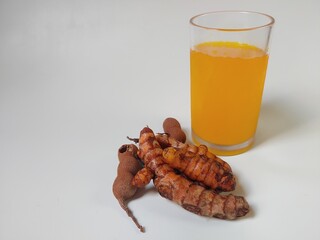 Jamu Kunyit Asam, traditional herbal drink made from turmeric and tamarind served in transparent glass with white background. popular Indonesian traditional drink. Immunity boosting, detox, diet.