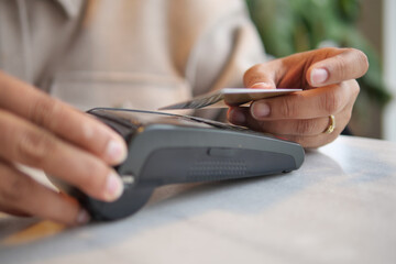 Customer using card reader for payment in cafe setting. contactless payment 