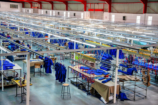textile factory indoors view from above, producing workwear for local market, african women workers in sewing machines