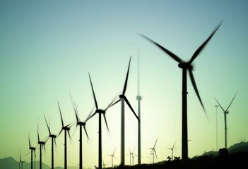 Wind turbines in a row against a blue and green sky