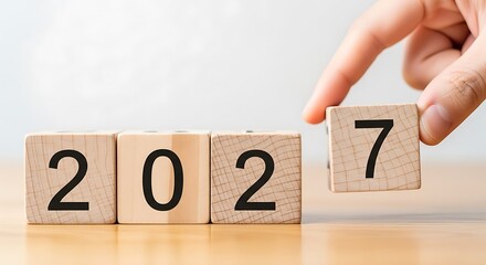 Hand placing number seven block to complete 2027 year