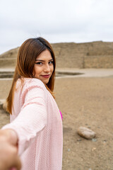 Fototapeta premium Tourist exploring pre inca ruins in peruvian desert holding hand