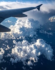 Fototapeta premium Airplane wing above fluffy clouds (1)