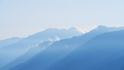 Obraz premium Layered blue mountain ranges fading into a pale sky haze