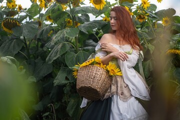 Redhead woman cradles basket of sunflowers amidst towering blooms, evoking a whimsical and ethereal...