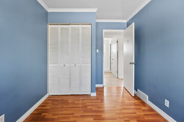 Bedroom with a white closet and a blue wall