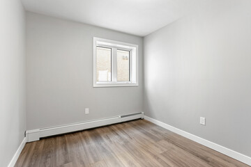 Small, empty room with a window and a radiator