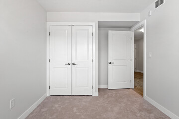 White bedroom with a white closet and a white door
