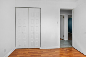 White room with a white door and a white closet