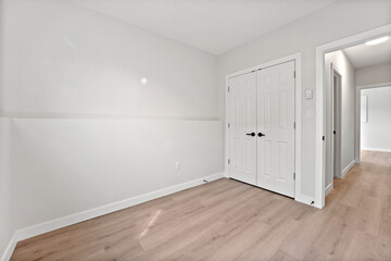 White room with a wooden floor and a white door