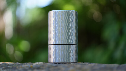 Textured Silver Container on a Stone Surface with Blurred Green Background