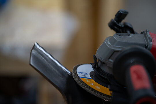 Angle Grinder with Flap Disc on Metal Edge