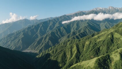 Panoramic mountain range with lush valleys and a hazy sky